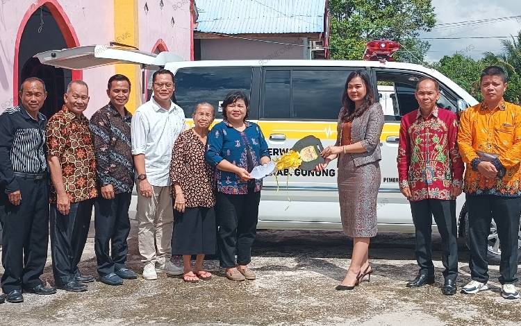 Anggota DPRD Gunung Mas Yuniwa saat menyerahkan kunci mobil kepada perwakilan wilayah GBI Gunung Mas Pendeta Friskila, Jumat, 30 Desember 2023. (FOTO: RISKA YULYANA)
