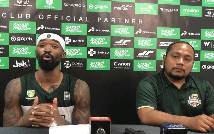 Asisten pelatih Borneo Hornbills Rimbun Sidauruk (kanan) bersama pemainnya Najeal Jewone Young (kiri) saat mengikuti sesi jumpa pers setelah timnya kalah 72-94 dari Satria Muda Pertamina pada laga pertama Indonesian Basketball League (IBL) 2024 di Hall Basket Gelora Bung Karno (GBK), Sabtu (13/1/2024). (ANTARA/Zaro Ezza Syachniar)