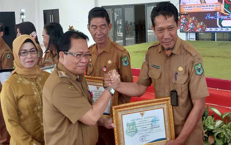 Pj Bupati Kapuas, Erlin Hardi saat serahkan piagam penghargaan kepada Direktur RSUD Kapuas, Agus Waluyo. (FOTO: IST)