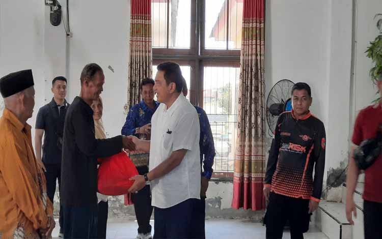 Pj Bupati Kobar Budi Santosa secara simbolis menyerahkan paket sembako untuk warga terdampak banjir di Desa Kumpai Batu Bawah. (Foto : DANANG)