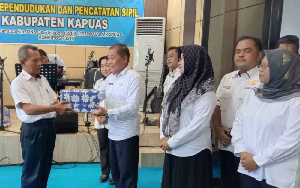 Plt Kepala Dinas Dukcapil Kapuas, Sipie S Bungai (kanan) saat berikan bingkisan kepada pegawai masuki masa purna tugas, Rabu, 31 Januari 2024. (FOTO: IST)