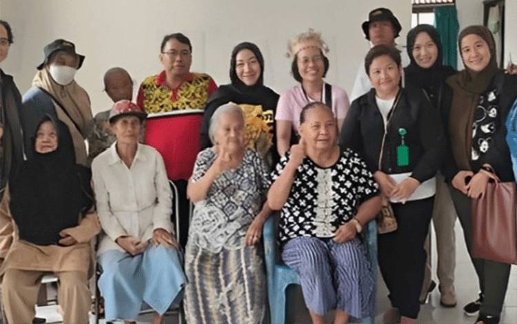 Kabid Rehabilitasi Sosial Dinsos Palangka Raya Sri Rimbawani (kerudung hitam tengah) saat berfoto bersama lansia usai mengantar ke PSTW Sinta Rangkang. (Foto : Dinsos Palangka Raya)