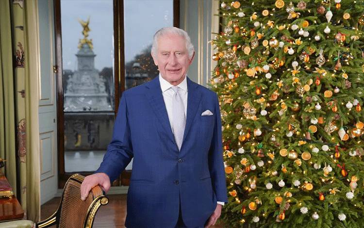 Raja Charles berdiri di samping pohon natal hidup yang merupakan tradisi baru di kerajaan untuk pesan Natal 2023 (ANTARA/X/The Royal Familiy)
