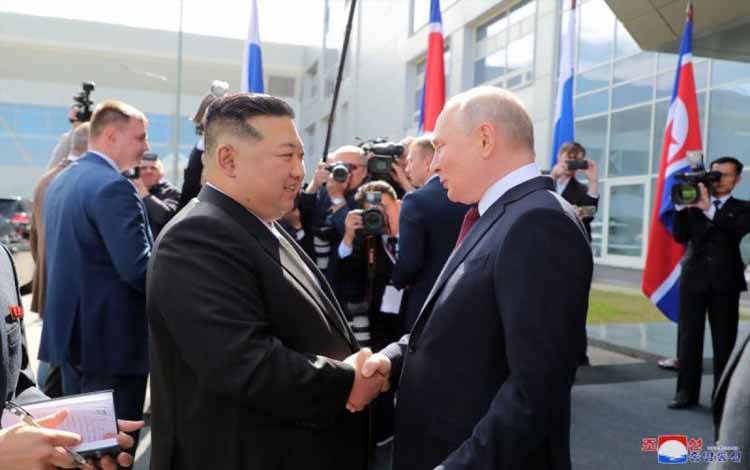 Pemimpin Korea Utara Kim Jong Un (kiri) berjabatan tangan dengan Presiden Rusia Vladimir Putin (kanan) saat kedua pemimpin negara melakukan pertemuan historis di Kosmodrom Vostochny di Oblast Amur, Distrik Timur Jauh, Rusia pada 13 September 2023. ANTARA/KCNA/tm