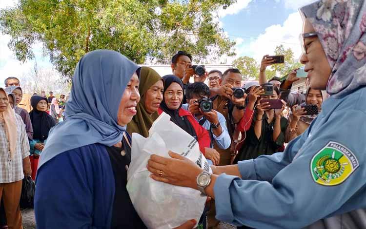 Pj Wali Kota Palangka Raya Hera Nugrahayu saat menyalurkan paket sembako pada kegiatan operasi pasar di Kelurahan Kameloh Baru (Foto : IST)