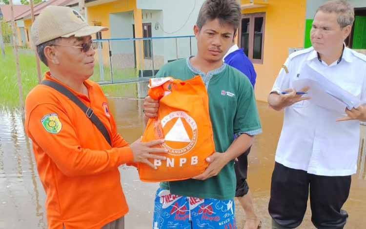 Kepala Bidang Kedaruratan dan Logistik BPBD Palangka Raya Sutarto saat memberikan bantuan paket sembako kepada masyarakat Jalan Matal (Foto : PATHUR)