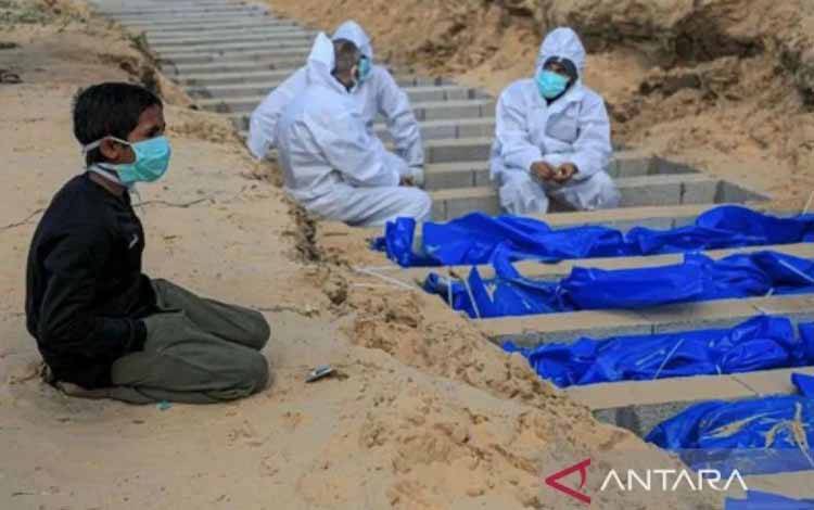 Seorang anak laki-laki berlutut di dekat kuburan para korban tewas dalam konflik Hamas-Israel di kota Rafah di Jalur Gaza selatan, pada Selasa (30/1/2024). (Xinhua/Rizek Abdeljawad)