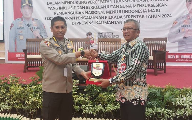 Kaban Kesbangpol Provinsi Kalteng, Katma F Dirun menerima cinderamata dari Polda Kalteng. (FOTO: DIRA)