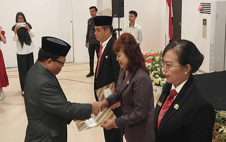 Pj Bupati Kapuas, Erlin Hardi saat menyerahkan SK pelantikan kepada Kepala Disparbudpora Kabupaten Kapuas, Appolonia. (FOTO: DODI)
