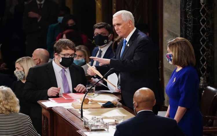 Wakil Presiden AS Mike Pence (tengah) dan Ketua DPR AS Nancy Pelosi (kanan) mengikuti sidang gabungan Kongres untuk mengesahkan hasil pemilu tahun 2020 di US Capitol di Washington, D.C., Amerika Serikat, 6 Januari, 2021. (Kevin Dietsch/Pool melalui Xinhua)