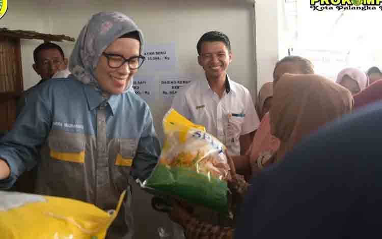 Pj Wali Kota Palangka Raya, Hera Nugrahayu saat menyalurkan beras SPHP di Kelurahan Kalampangan.(FOTO: HUMAS)