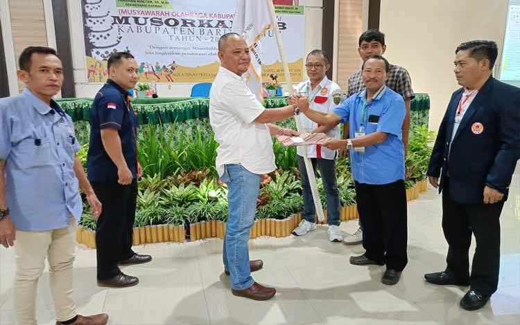 Muniko Kurniawan menerima pataka bendera KONI setelah terpilih sebagai Ketua Umum KONI Barito Timur periode 2024-2028 dalam Musorkablub yang digelar di Aula Dinas Pertanian dan Ketahanan Pangan Barito Timur, Sabtu, 30 Maret 2024. (FOTO: BOLE MALO)