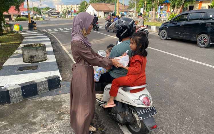 Dewan Guru dan PDBK SLBN 1 Sukamara membagikan takjil gratis kepada pengendara di Taman Baca atau area lampu merah. (FOTO : NORHASANAH)
