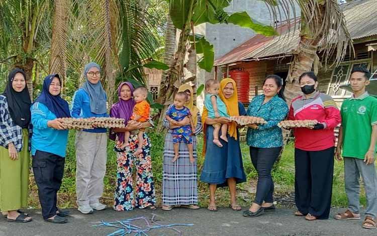 Camat Pematang Karau Setia Murni (tiga dari kiri), saat menyalurkan Telur Bantuan Aparatur Sipil Negara (Telasting) kepada 15 balita berisiko stunting, Jumat, 5 April 2024. (FOTO: IST)
