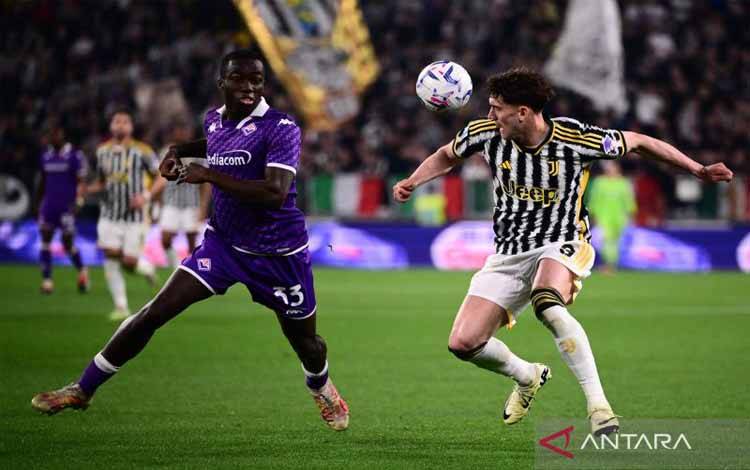 Bek Fiorentina Michael Kayode (kiri) berduel memperebutkan bola dengan penyerang Juventus Dusan Vlahovic (kanan) pada pertandingan Liga Italia di Stadion Allianz, Turin, Minggu (7/4/2024). (ANTARA/AFP/MARCO BERTORELLO)