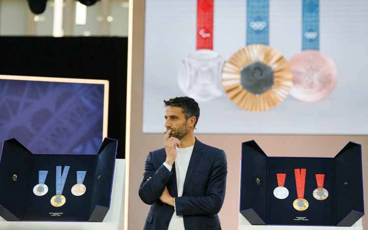 Presiden Panitia Pelaksana Olimpiade Paris 2024 Tony Estanguet berpose bersama medali Olimpiade dan Palimpiade Paris 2024, di Paris pada 8 Februari 2024. AFP/DIMITAR DILKOFF