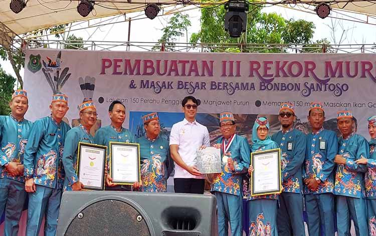 Penyerahan piagam penghargaan dari Perwakilan Muri kepada Pj Bupati Kapuas, Erlin Hardi atas pemecahan tiga rekor. (FOTO: IST)