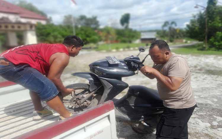 Anggota Polsek Sebangau Cecep saat membantu masyarakat mengangkat kendaraan pasca kecelakaan lalu lintas area Kalampangan Kota Palangka Raya (Foto: MARINI)
