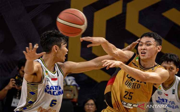 Pebasket Dewa United Banten Dio Tirta Saputra (kanan) mengoper rekannya dengan dibayangi pebasket Satya Wacana Salatiga Calvin Yeremias Biyantaka (kiri) pada pertandingan lanjutan IBL 2024 di Knight Stadium, Semarang, Jawa Tengah, Sabtu (4/5/2024). Dewa United Banten Menang atas Satya Wacana Salatiga dengan skor 92-57. ANTARA FOTO/Aji Styawan/aww.