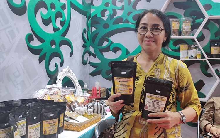 Anggota KIM Bintang Jaya Itah, Nike saat memamerkan produk herbal di stan Disdagperin di Kalteng Expo 2024. (FOTO: HERMAWAN)