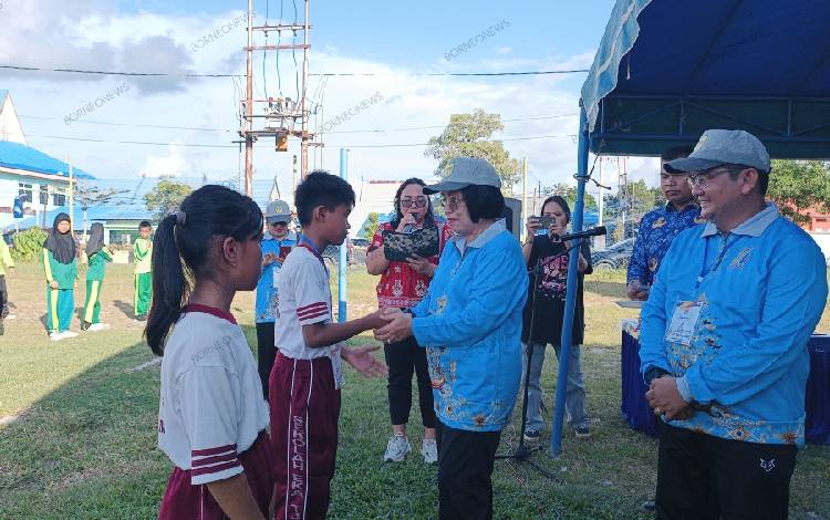 Wakil Bupati Gunung Mas Efrensia L.P Umbing saat bersalaman dengan peserta O2SN tingkat Kabupaten untuk jenjang SD, Jumat, 17 Mei 2024. (FOTO: RISKA YULYANA)