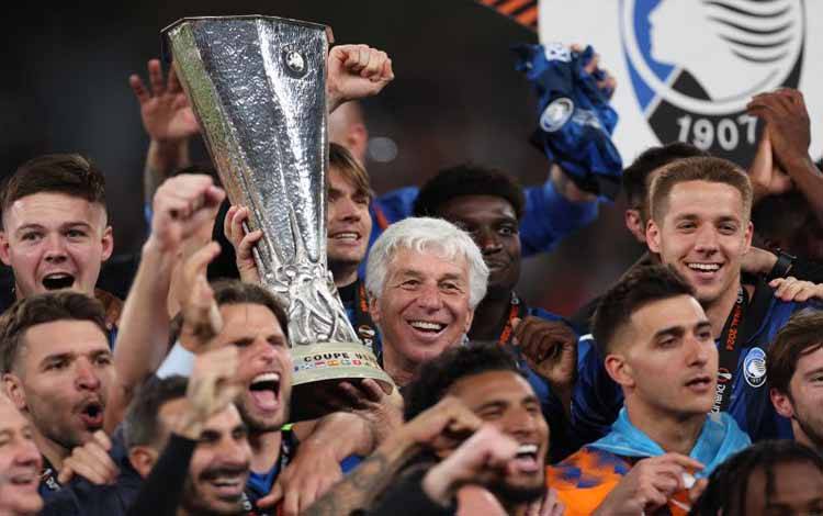 Pelatih Atalanta Gian Piero Gasperini (tengah) dan para pemain Atalanta merayakan keberhasilan mereka menjuarai Liga Europa setelah dalam final mengalahkan Bayer Leverkusen di Stadion Dublin Arena, Dublin, Irlandia, pada 22 Mei 2024. (Photo by Adrian DENNIS / AFP) (AFP/ADRIAN DENNIS)