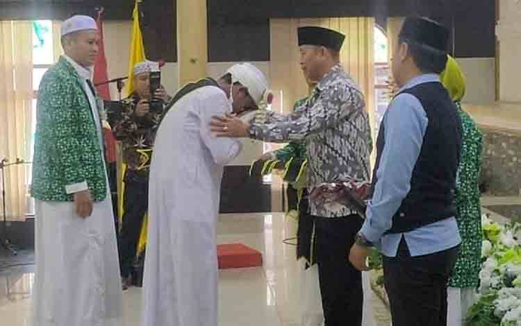 Asisten II Setda Barito Timur Amrullah, menyalami para ulama saat menghadiri Wisuda Khotmil Qur'an santri dan santriwati Taman Pendidikan Qur'an atau TPQ Al-Fitrah Tamiang Layang, Kamis 23 Mei 2024. (FOTO: IST)