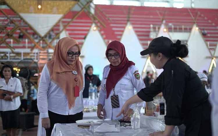 Kepala Dinas Adiah Chandra Sari bersama Kepala Dinas Koperasi dan UMKM Norhani mendatangi salah satu meja peserta yang sedang berlomba baru baru ini. (FOTO: IST)
