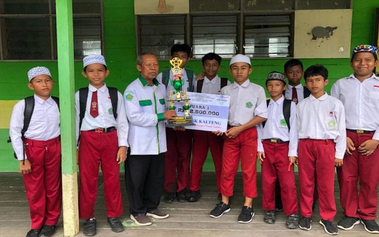 Kepala MIN 1 Kapuas, Ahmad Yani bersama peserta didik Tim Mini Soccer. (FOTO: IST)
