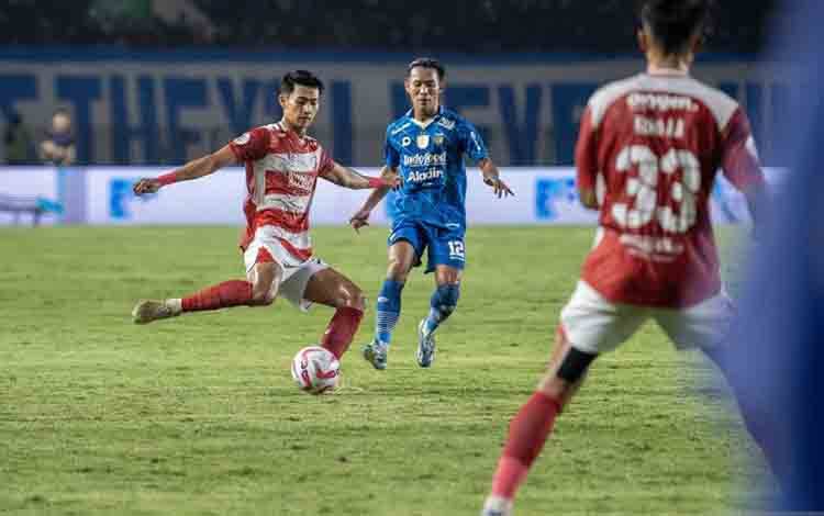 Pesepak bola Madura United Malik Risaldi (kiri) berusaha menggiring bola dibayangi pesepak bola Persib Bandung Henhen Herdiana (kedua kiri) saat pertandingan leg pertama final Championship Series-BRI Liga 1 di Stadion Si Jalak Harupat, Kabupaten Bandung, Jawa Barat, Minggu (26/5/2024). ANTARA FOTO/M Agung Rajasa/rwa.