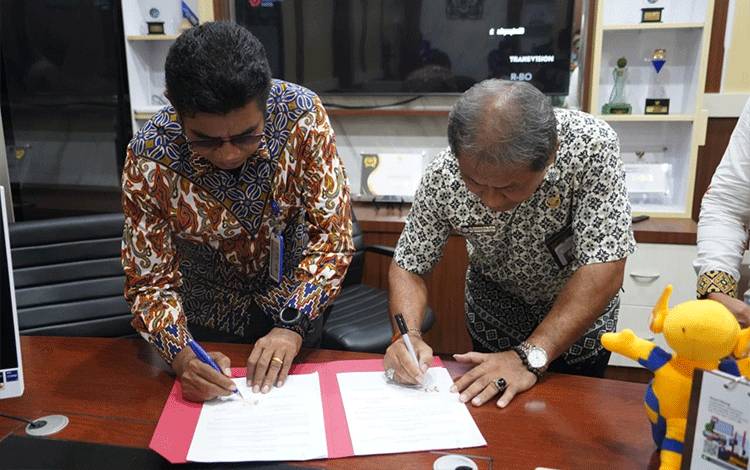 Kepala Diskominfosantik Provinsi Kalteng Agus Siswadi bersama Rektor Institut Agama Hindu Negeri Tampung Penyang Palangka Raya Mujiyono saat menandatangani Nota Kesepahaman. (FOTO: RIZALDI)