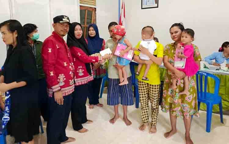 Kades Pulau Kaladan, Sugianto saat menyerahkan bonus kepada warga aktif ikuti Posyandu. (FOTO: IST)