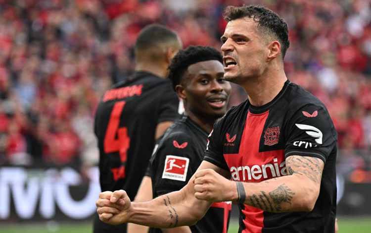 Gelandang Bayer Leverkusen asal Swiss Granit Xhaka melakukan selebrasi usai mencetak gol pada pertandingan Bundesliga melawan Werder Bremen di Leverkusen, 14 April 2024. (AFP/INA FASSBENDER)
