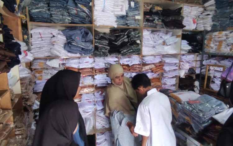 Seorang pembeli memastikan ukuran baju di salah satu toko seragam Pasar Berdikari, Sampit.