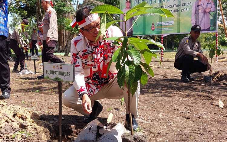 Pj Bupati Kapuas, Erlin Hardi saat lakukan penanaman pohon kegiatan menyambut Hari Bhayangkara ke-78 yang diadakan Polres Kapuas, Kamis, 27 Juni 2024. (FOTO: DODI)
