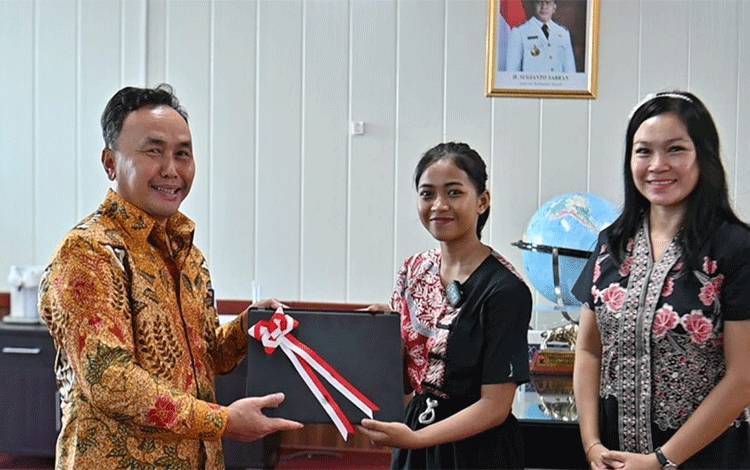Gubernur Kalimantan Tengah (Kalteng), Sugianto Sabran menyerahkan bantuan laptop presiden kepada siswi SMKN 1 Kuala Kurun, Putri Eno Desi Andriyani, Jumat, 28 Juni 2024. (FOTO:DISDIK KALTENG)