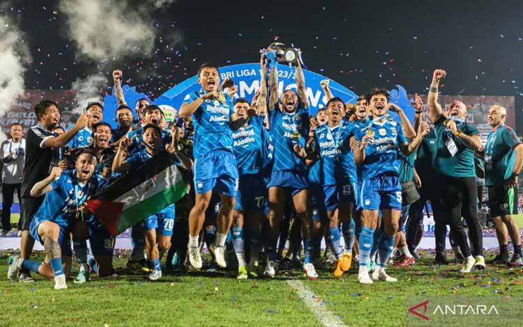 Pesepak bola Persib Bandung dan ofisial tim mengangkat piala usai menjadi juara BRI Liga 1 2023/2024 di Stadion Gelora Bangkalan, Bangkalan, Jawa Timur, Jumat (31/5/2024). Persib Bandung mengalahkan Madura United dengan agregat gol 6-1. ANTARA FOTO/Rizal Hanafi/aww.