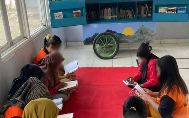 WBP Perempuan Rutan Kapuas saat baca buku di lapak Gerobak Literasi. (FOTO: IST)