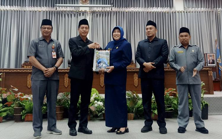 Pj Bupati Barito Utara, Drs Muhlis didampingi Pj Sekda Jufriansyah menyerahkan dokumen KUA dan PPAS tahun anggaran kepada Ketua DPRD Barito Utara, Hj Mery Rukaini didampingi Waket I dan Waket II, pada rapat paripurna I di gedung DPRD setempat, Senin 15 Juli 2024. (foto: Dhani)