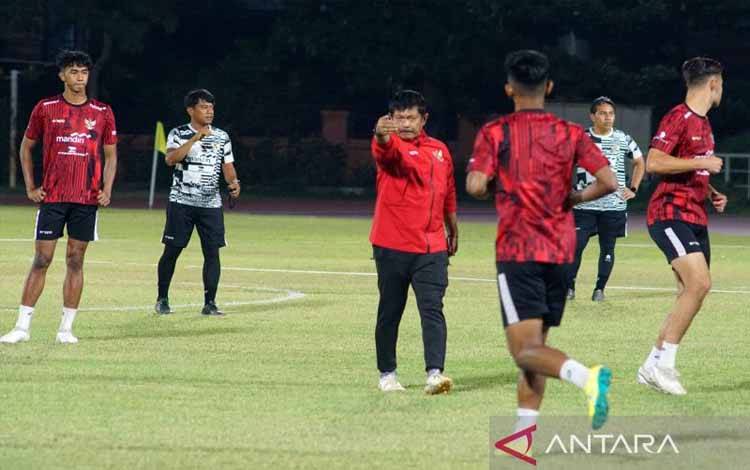 Pelatih Timnas Indonesia U-19 Indra Sjafri (tengah) memberikan instruksi kepada para pemainnya saat berlatih di Lapangan Thor Surabaya, Kamis (11/7/2024) malam. (ANTARA/Naufal Ammar Imaduddin))