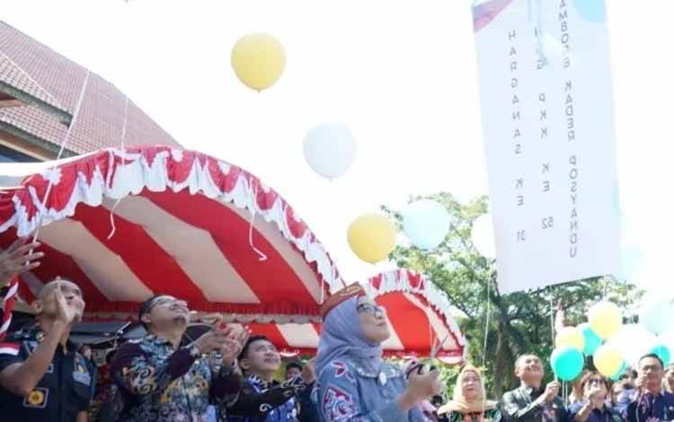 Pj Wali Kota Palangka Raya Hera Nugrahayu melepaskan balon tanda peringatan Harganas Ke - 31 dan hari kesatuan gerak PKK (Foto : Prokopim)