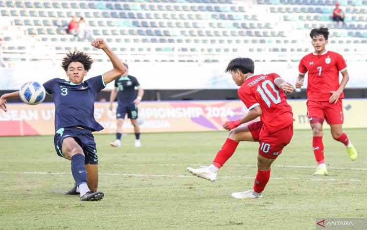 Pemain Thailand U-19 Thanakrit Chotmuangpak (tengah) berusaha menendang bola ke arah gawang Australia pada babak semifinal ASEAN U-19 Boys Championship di Stadion GBT Surabaya, Sabtu (27/7/2024) sore. ANTARA FOTO/Rizal Hanafi