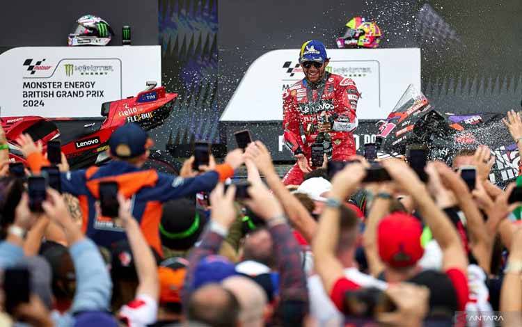Pembalap Ducati Tim Lenovo Italia Enea Bastianini merayakan di podium setelah memenangkan sprint race MotoGP Grand Prix Inggris di sirkuit Silverstone di Northamptonshire, Inggris tengah, pada Sabtu (3/8/2024). (ANTARA/AFP/Benjamin Cremel)