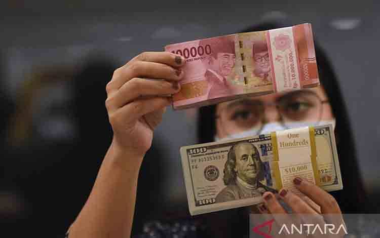 Ilustrasi - Pegawai menunjukkan mata uang rupiah dan dolar AS di salah satu gerai penukaran mata uang di Jakarta, ANTARA FOTO/Indrianto Eko Suwarso/YU/aa.