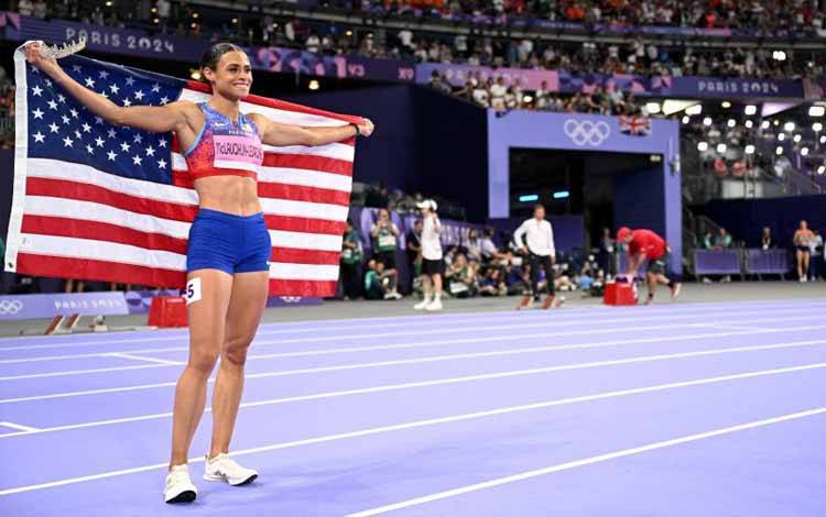 Pelari AS Sydney Mclaughlin-Levrone merayakan kemenangan dengan memecahkan rekor dunia nomor lari gawang 400m putri dalam final cabang olahraga atletik Olimpiade Paris 2024 di Stade de France, Prancis, Kamis (8/8/2024). (ANTARA/AFP/Kirill Kudryavtsev)