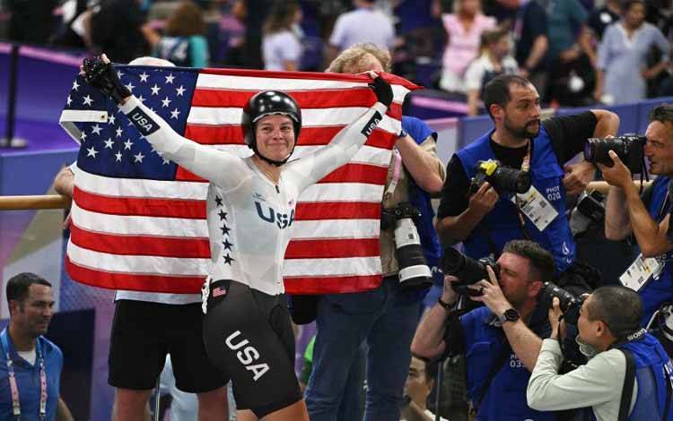 Pebalap sepeda Amerika Serikat Jennifer Valente merayakan keberhasilannya memenangkan medali emas balap sepeda trek omnium putri Olimpiade Paris 2024 di Velodrom Saint-Quentin-en-Yvelines di Montigny-le-Bretonneux, Paris, pada 11 Agustus 2024. (AFP/SEBASTIEN BOZON)