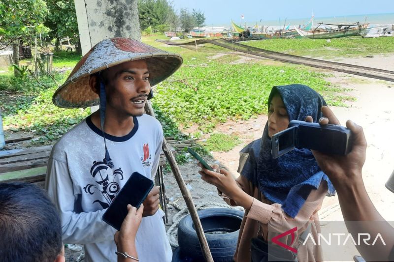 Salah seorang nelayan di Desa Taluak, Kecamatan Pariaman Selatan, Kota Pariaman, Sumbar, diwawancarai oleh sejumlah wartawan dengan latar sejumlah kapal bersandar di tepi pantai karena nelayan tidak bisa melaut. ANTARA/Aadiaat M. S.