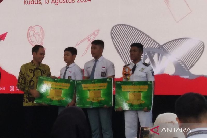 Pemimpin PT Pegadaian Kanwil XI Semarang Edy Purwanto saat menyerahkan bantuan buku rekening tabungan emas kepada siswa SMK Wisuda Karya Kudus pada acara edukasi keuangan bagi generasi muda menuju Indonesia Emas 2025, di SMK Wisuda Karya Kudus, Selasa (13/8/2024). ANTARA/Akhmad Nazaruddin Lathif