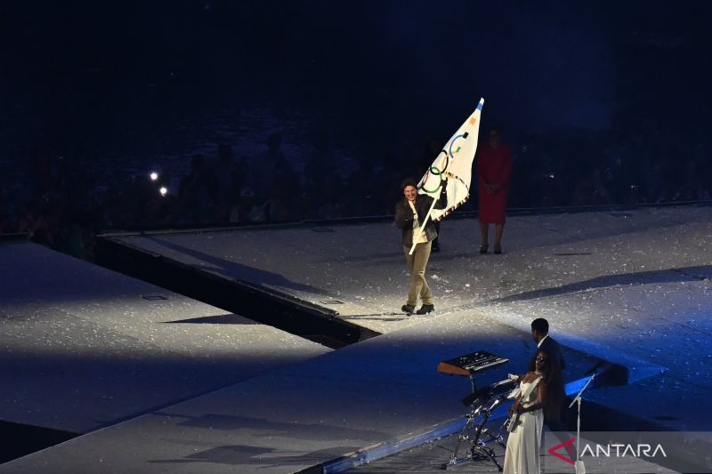 Aktor Tom Cruise membawa bendera olimpiade saat penyerahan ke tuan rumah selanjutnya pada penutupan Olimpiade Paris 2024 di Stadion Stade de France, Paris, Prancis, Minggu (11/8/2024). ANTARA FOTO/Wahyu Putro A/YU (ANTARA FOTO/WAHYU PUTRO A)