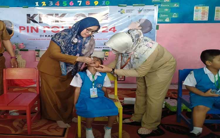 Kepala Dinas Kesehatan (Dinkes) Sukamara Ari Junita memberikan vaksin polio kepada anak TK Pembina 2. (FOTO:NORHASANAH)